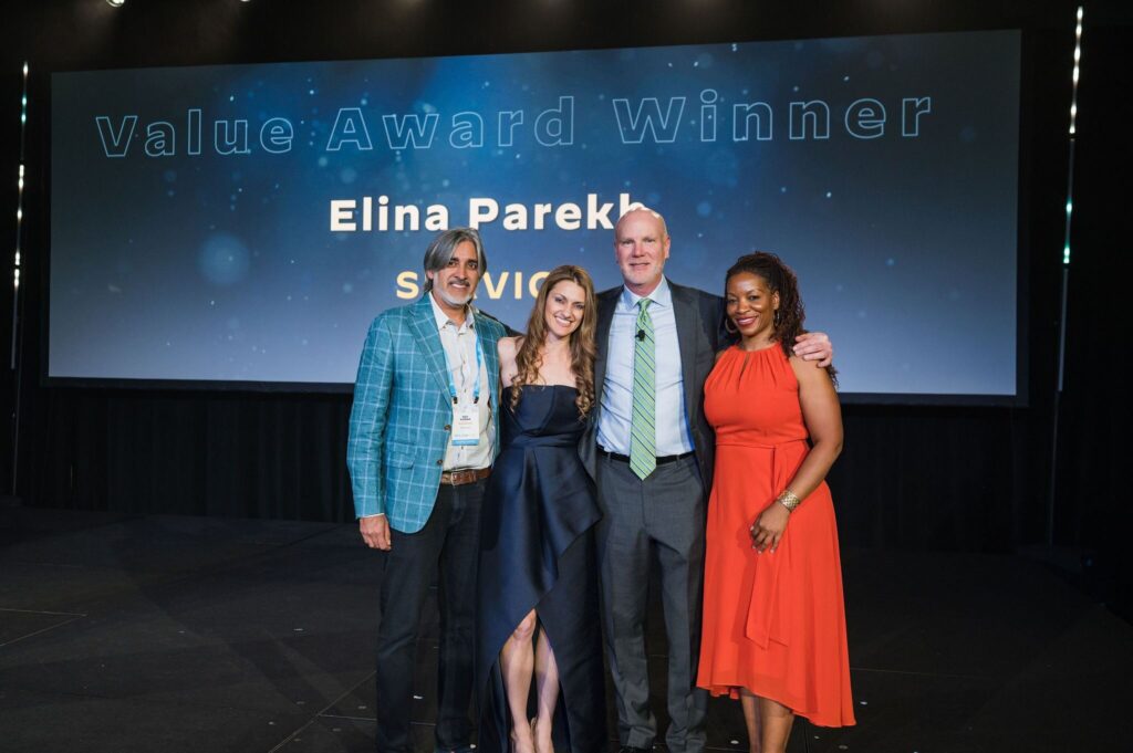 two men and two women stand smiling on stage