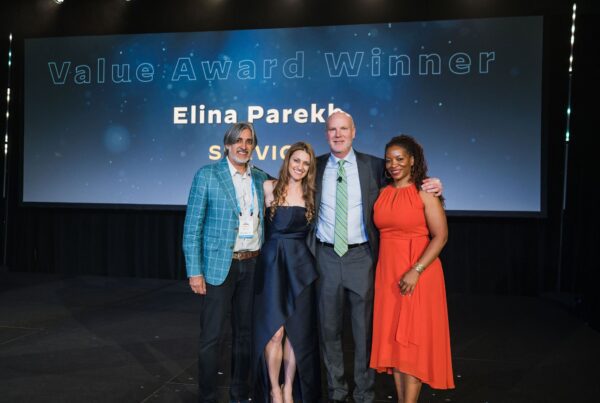 two men and two women stand smiling on stage