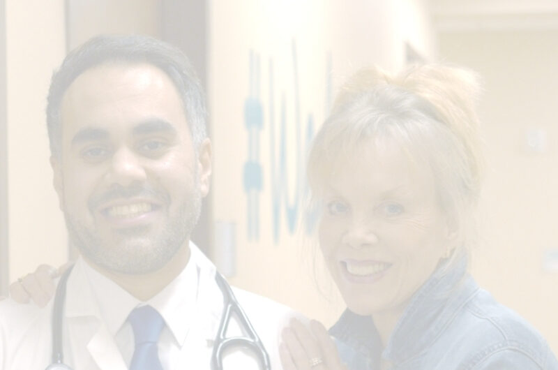 A doctor with a stethoscope around his neck stands next to a smiling woman in an RP clinic hallway, both looking at the camera. The image is faded and softly lit.